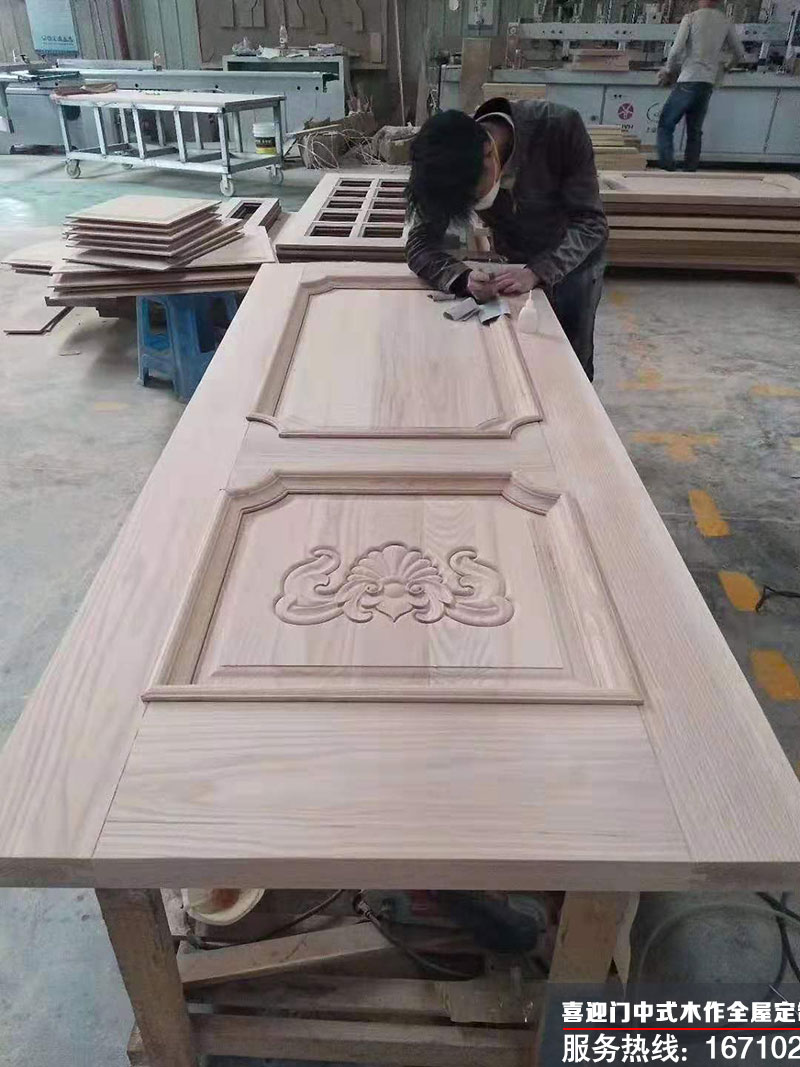 喜迎門師傅對中式木門的紋理進行現場雕刻作業